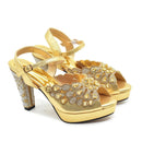 Gold high-heeled shoes with floral embellishments on a white background, Obroi