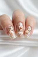 A nail art mold template shown next to a close-up of manicured fingernails decorated with 3D seashell and starfish nail art in glittery nude polish, Obroi