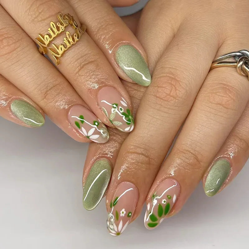 Close-up of hands with green and pink nail polish on a white background