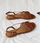 Pair of brown sandals on a white surface, Obroi