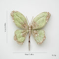 Decorative butterfly hairpin with green wings and gold accents on a white background, Obroi