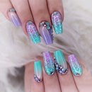 Multicolored glittery nails with decorative elements on a neutral background