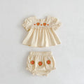 Baby outfit with top and bloomers featuring floral embroidery on a light gray background, Obroi