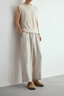 Person wearing beige wide-leg pants and shoes against a plain background, Obroi