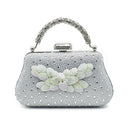 Silver clutch bag with floral embellishments on a white background, Obroi