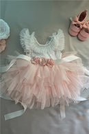 Delicate baby dress with floral details and ruffled sleeves on a soft surface, Obroi
