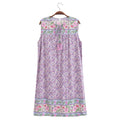 A sleeveless lavender floral nightgown dress with embroidered floral borders and a tassel tie at the neckline, hanging on a wooden hanger against a white background, Obroi