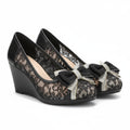 Black wedge shoes with floral lace and bow details on a white background, Obroi