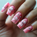 Nails with pink floral design and rhinestones on a light background, Obroi