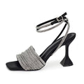Black high-heeled shoe with silver embellishments on a white background, Obroi