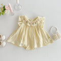 Yellow baby dress with floral embroidery on a light gray background, Obroi