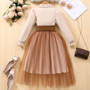Two-tone dress with beige top and brown skirt on a wooden surface with accessories, Obroi