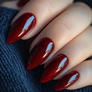 Close-up of a hand with red nail polish on a dark textured background, Obroi
