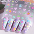 Pastel nail art stickers with decorative elements on a clear sheet, with a set of applied nails in the foreground, Obroi