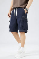 Person wearing navy cargo shorts on a white background, Obroi