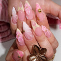 Hand with pink and gold floral nail art on a blurred background, Obroi