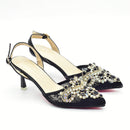 Black high-heeled shoes with gold embellishments on a white background, Obroi