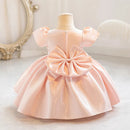 Pink dress with a large bow on a mannequin against a neutral background, Obroi