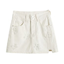 White denim skirt with floral embroidery on a white background, Obroi
