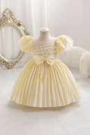 Yellow dress on a mannequin with decorative elements in a soft, blurred background, Obroi