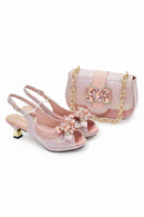 Pink high-heeled shoes and matching handbag with decorative elements on a white background, Obroi