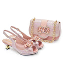 Pink high-heeled shoes and matching handbag with decorative elements on a white background, Obroi