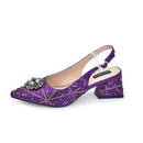 A single purple glitter slingback pump with a jeweled embellishment on the toe, a low block heel, and a white ankle strap, shown against a plain white background, Obroi
