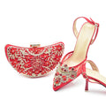 Red high-heeled shoe and matching handbag with intricate designs on a white background, Obroi
