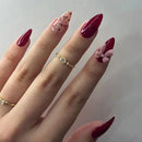 Close-up of a hand with red and pink nail polish on a plain background, Obroi