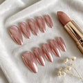 Set of pink nail extensions and a lipstick on a white surface with small flowers, Obroi