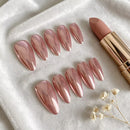 Set of pink nail extensions and a lipstick on a white surface with small flowers, Obroi