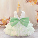 A toddler girl's sleeveless party dress displayed on a dress form mannequin. The dress features a white lace V-neck bodice, a tiered ruffled skirt with a light green floral pattern, and a large mint green satin bow at the waist, Obroi