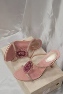 Pink high-heeled sandals with decorative pink gemstones on a light background, Obroi