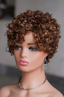 Mannequin head with a brown curly wig on a blurred background, Obroi