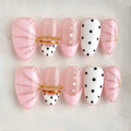 Set of pink and white nail art with polka dots and gold accents on a neutral background, Obroi