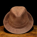 Brown suede hat on a wooden surface with a black background, Obroi