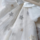 White tulle dress with sequined star embellishments in silver and gold, featuring a white satin collar, Obroi