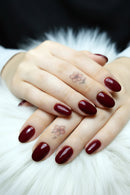 Close-up of hands with dark red nail polish on a white background, Obroi