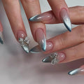 Close-up of hands with silver and pink gradient nails featuring decorative bow designs, Obroi