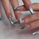Close-up of hands with silver and pink gradient nails featuring decorative bow designs, Obroi