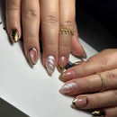 Close-up of hands with gold and nail art on a white background, Obroi
