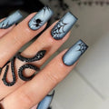 Nails with spider and web design on a light blue gradient background, Obroi