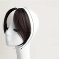 Pack of 2 black brown hair extensions on a mannequin head with close-up of one extension, Obroi