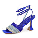 Blue high-heeled sandal with decorative straps on a white background, Obroi