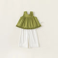 Green top and white pants set on a light beige background, Obroi