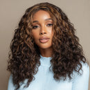 Woman with long, wavy hair wearing a light blue top against a beige background, Obroi