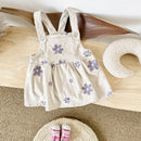 Beige dress with purple floral patterns on a wooden surface, Obroi