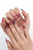 Hand with red and silver nail art on a white background, Obroi