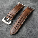 Brown leather watch strap with silver buckle on a gray background, Obroi