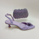 Purple high-heeled shoes with matching handbag on a light gray background, Obroi